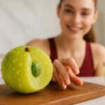 Juicy fresh amla fruit on a cutting board with a woman in red yoga dress, highlighting daily beauty and health benefits.
