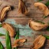 Close-up of dried coconut husk fibers intertwined with green leaves on a weathered wooden surface, symbolizing eco-friendly, spiritual, and practical uses of coconut husks in sustainable living.