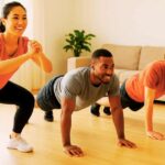A diverse group of beginners performing easy calisthenics exercises like squats and planks in a living room at home with no equipment.